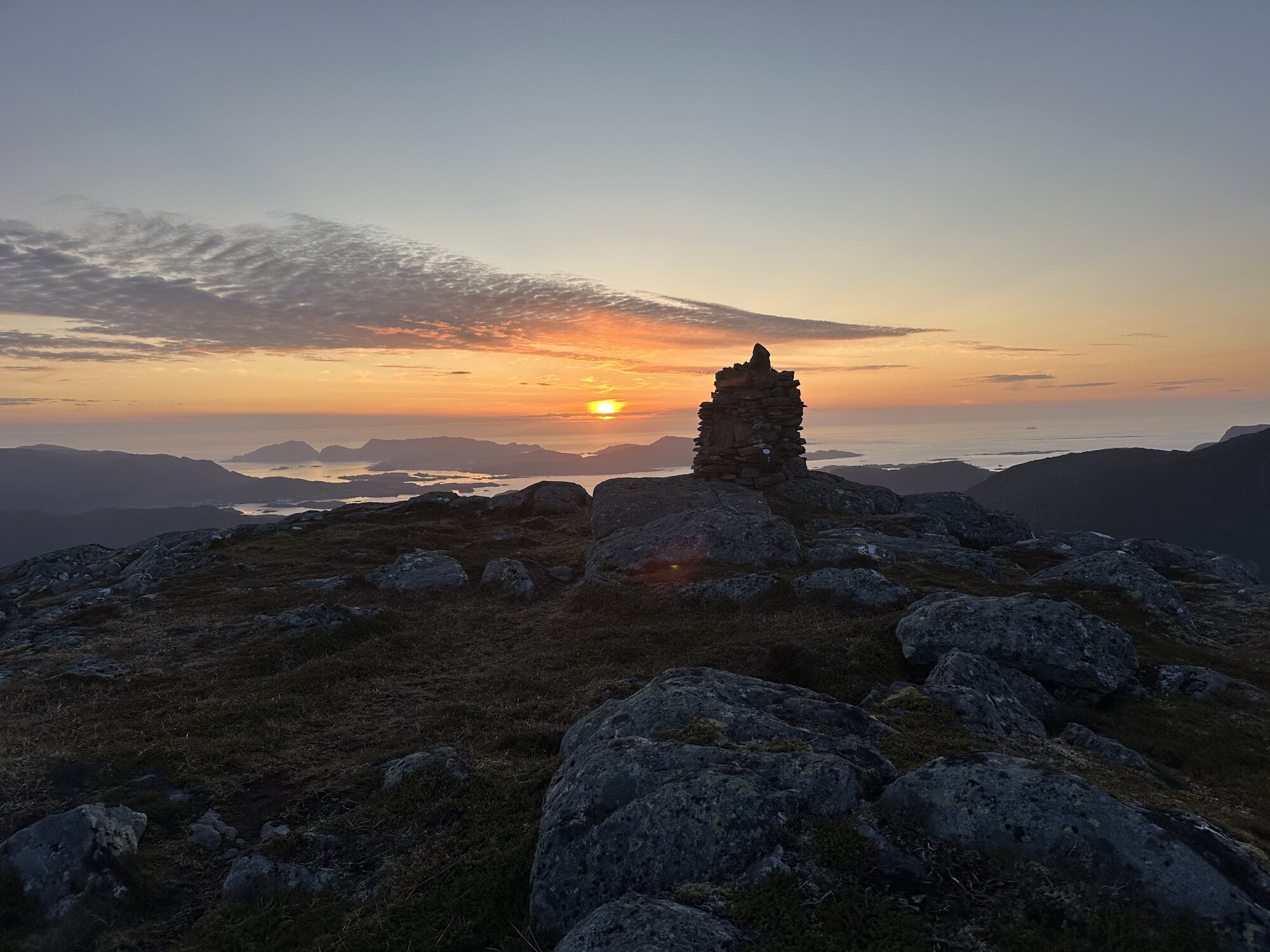 Varden på Blåtinden i solnedgang med utsikt over øyane og havet